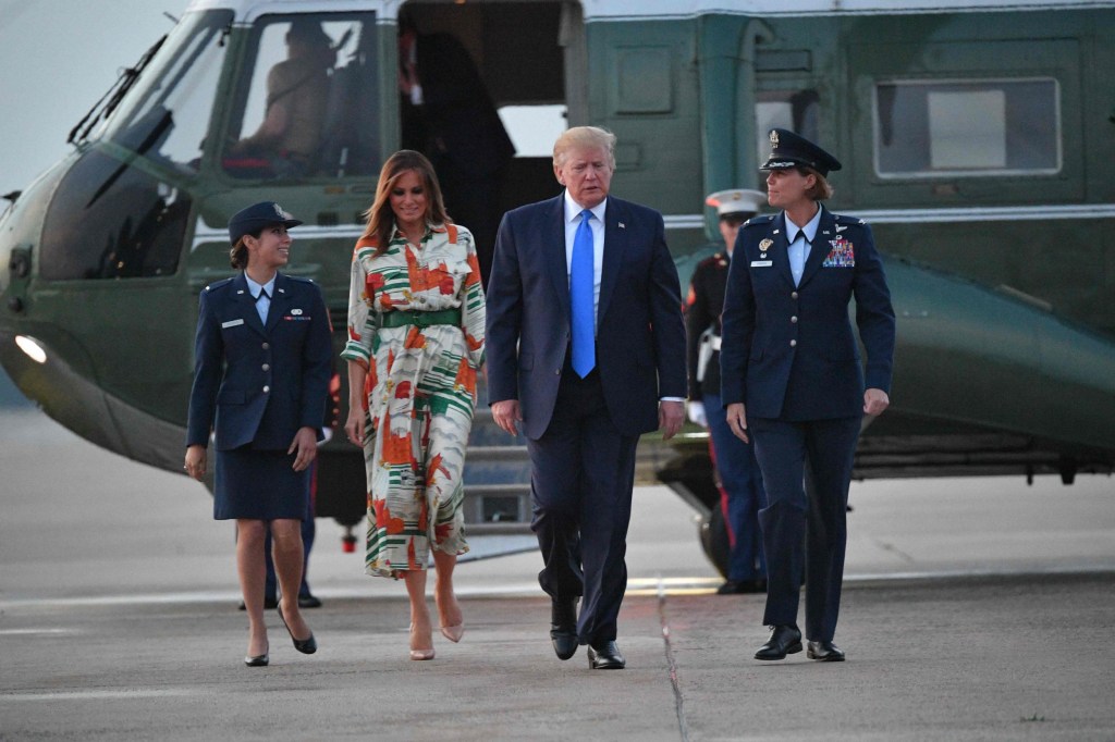 Le président américain Donald Trump et la première dame Melania Trump sont descendus de Marine One et se sont rendus à bord d'Air Force One avant de quitter la base aérienne d'Andrews dans le Maryland et peuvent être vus s'éloigner sur le tarmac avec trois officiers en arrière-plan.