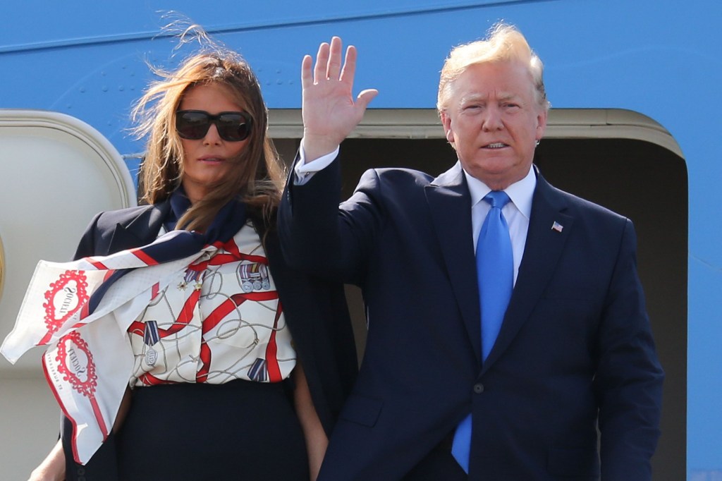 Le président des États-Unis Donald Trump et la première dame Melania Trump lorsqu'ils débarquent d'Air Force One à l'aéroport de Stansted. Trump portait un costume bleu foncé et une cravate bleu vif, tandis que Melania a opté pour une jupe crayon bleu marine associée à un chemisier imprimé blanc et bleu et une veste bleu marine.