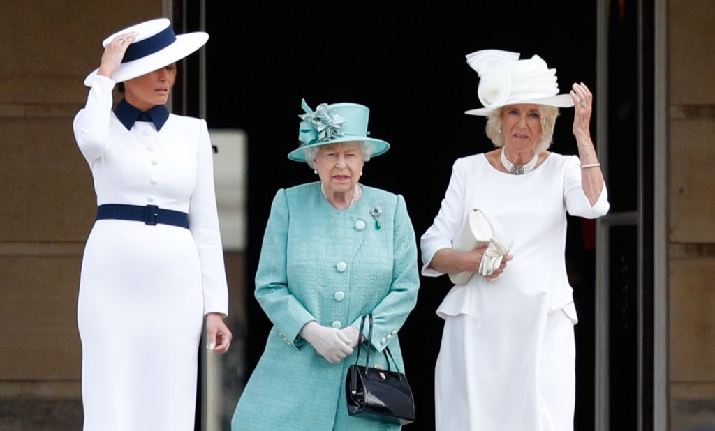 La Première Dame Melania Trump aux côtés de la reine Elizabeth II et de Camilla, duchesse de Cornouailles. Tous les trois ont associé leurs tenues à des chapeaux